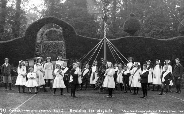 Children with maypole on edge of tennis court